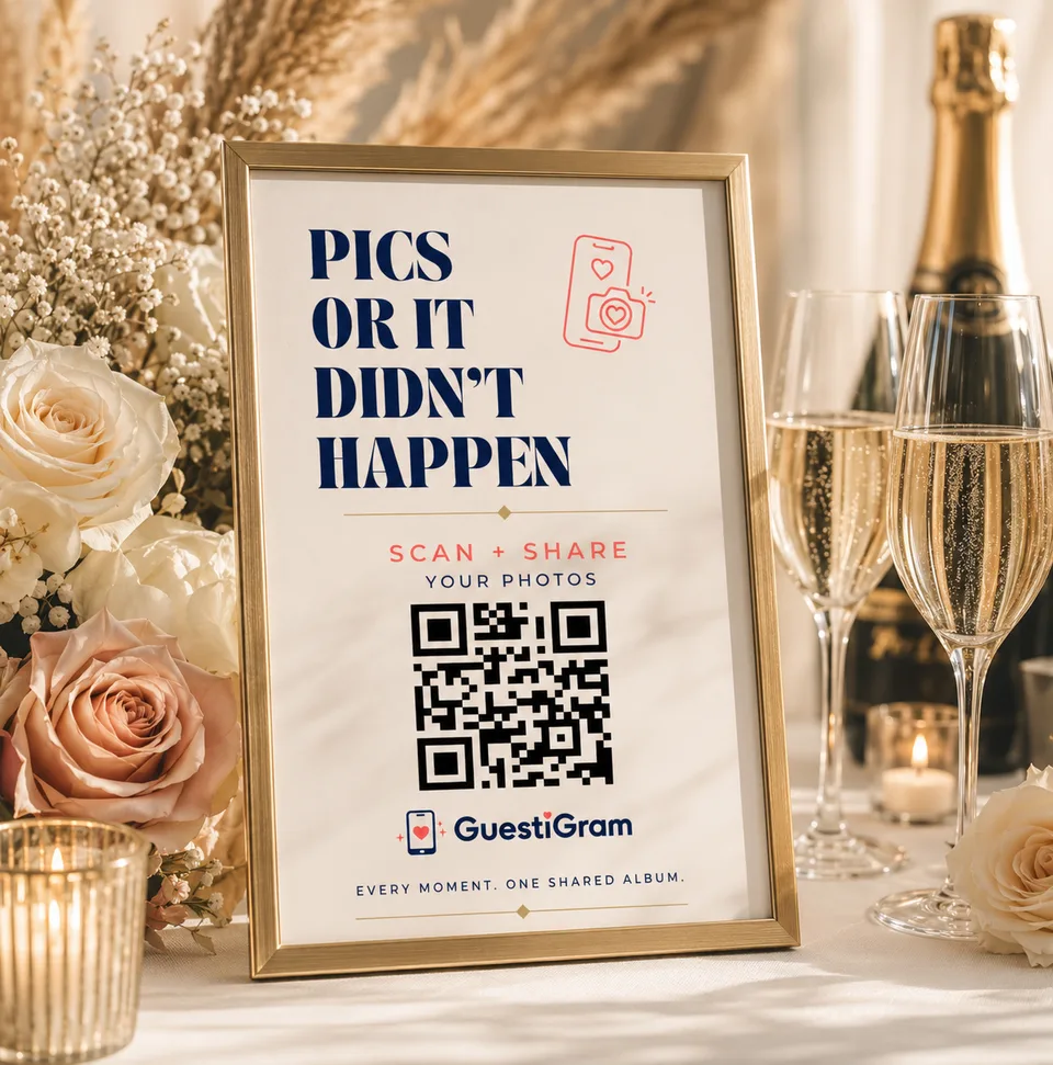 A gold-framed GuestiGram QR sign reading Pics or it didn’t happen, beside wedding flowers and champagne